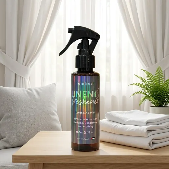 Linen Freshener beside folded towels by a window